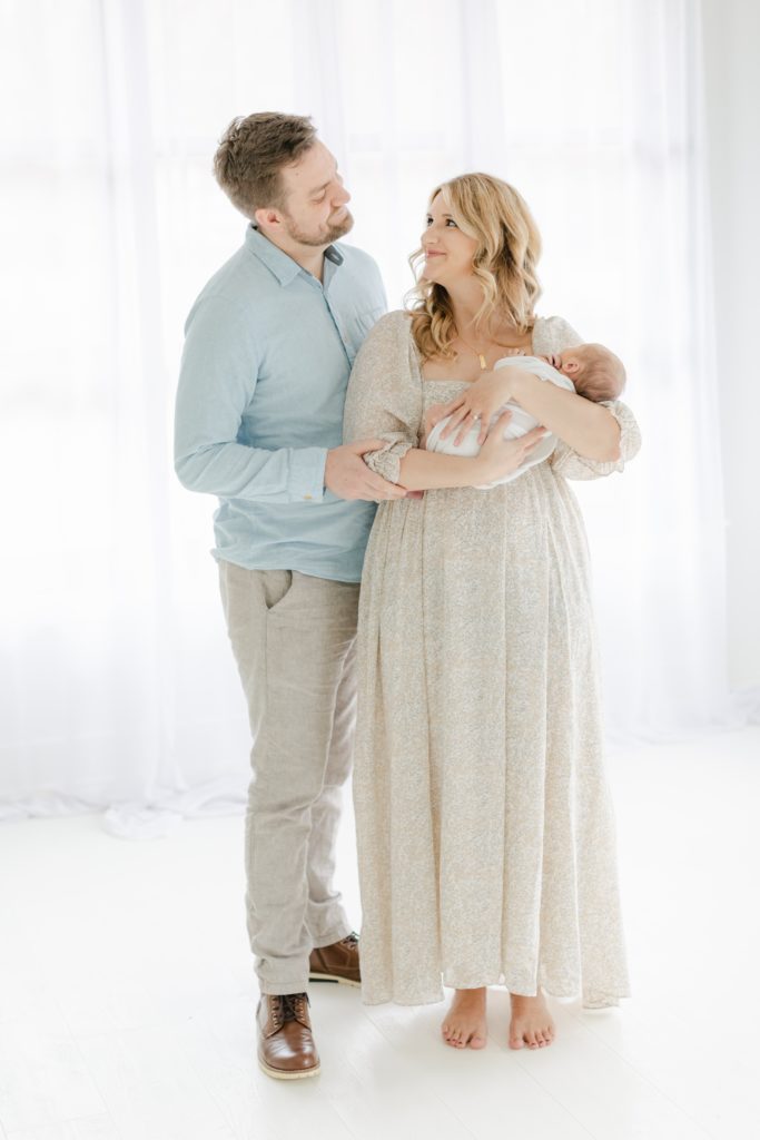 Man, woman, and newborn baby in a studio as an example of studio newborn session Atlanta