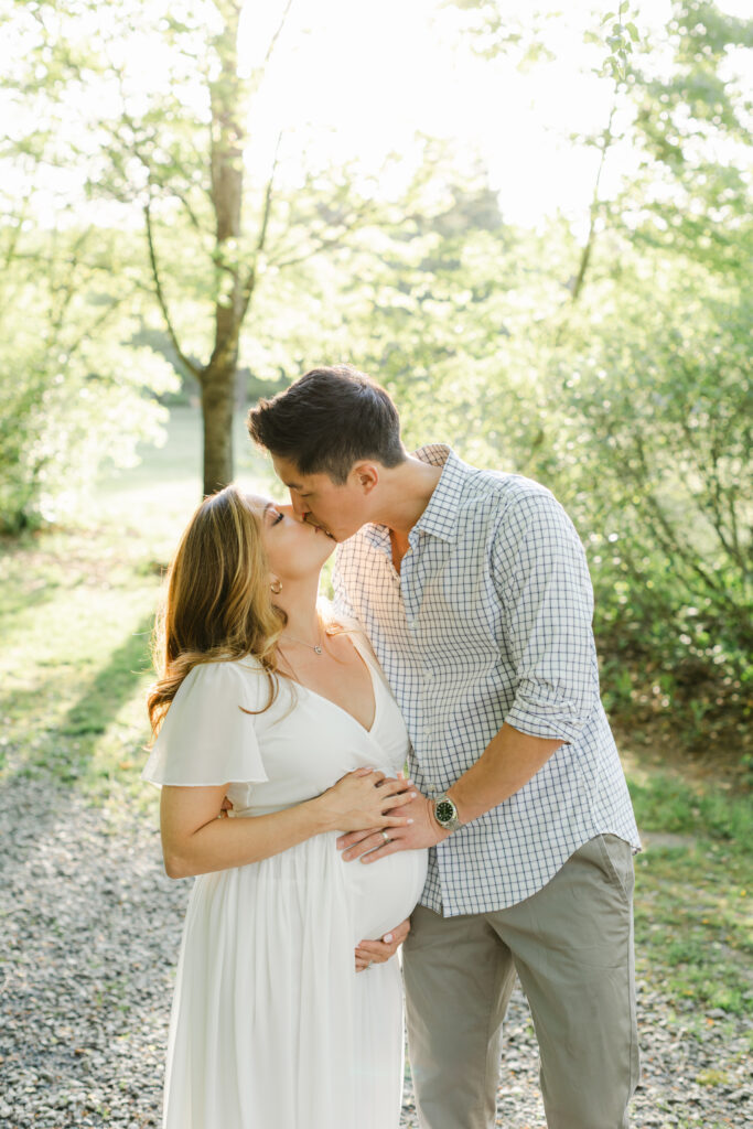 Pregnant couple kissing  in the park as an example of date night ideas in Atlanta