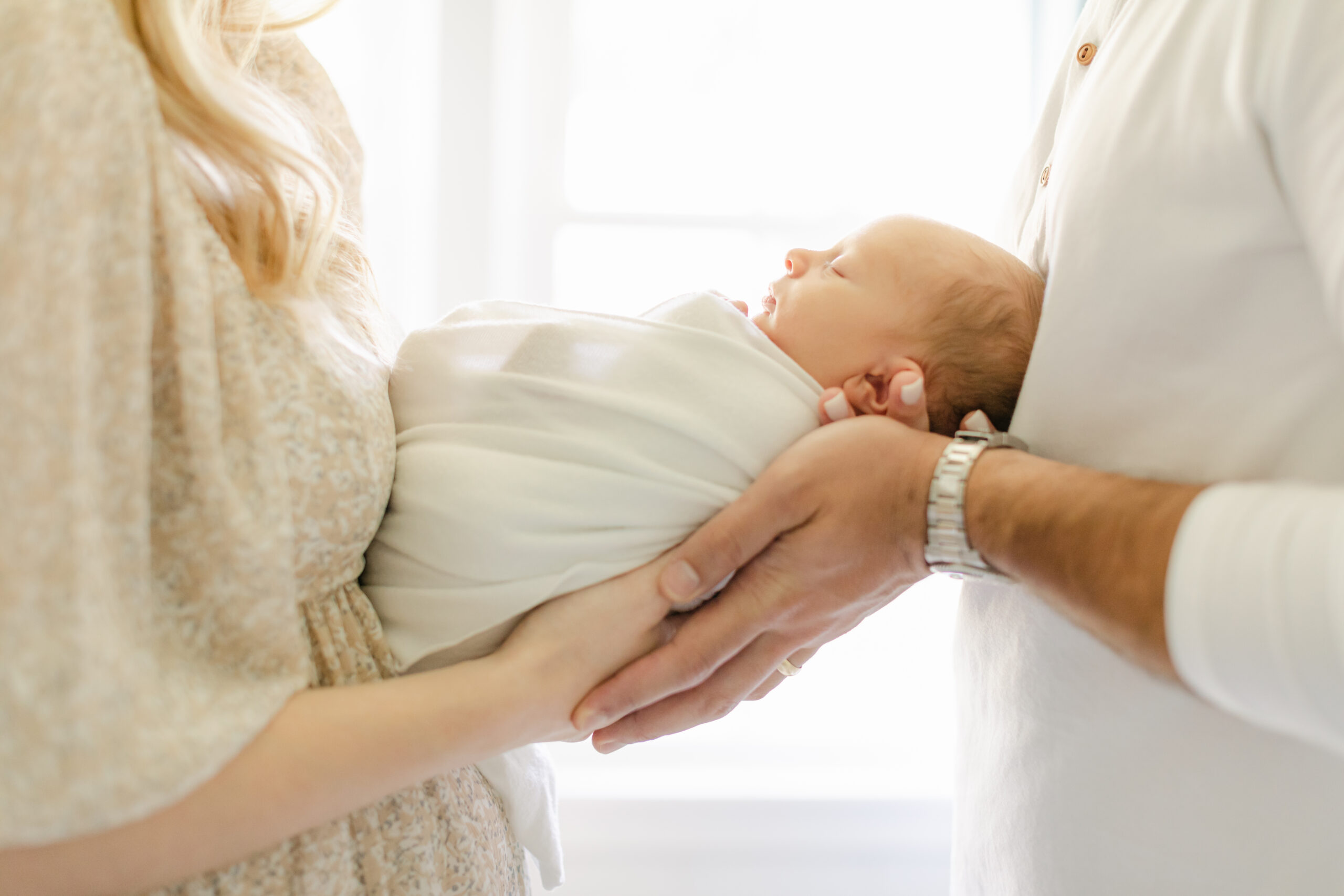 newborn being held by parents as an example of Alpharetta newborn photographer